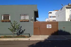 a building with a brown door with a sign on it at Apto Prático n.07 in Cascavel