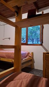 埃爾博爾松的住宿－HOSTEL EL LIMON，一间卧室设有两张双层床和一扇窗户。
