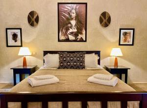 een slaapkamer met een groot bed en 2 tafels bij Dar Zeitoun in Marrakesh