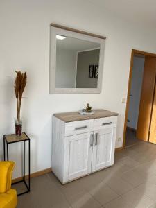 a white cabinet in a room with a mirror at Sunset Apartment mit Rheinblick in Urbar in Urbar +23 photos