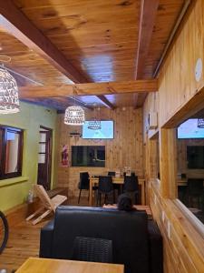 comedor con paredes de madera, mesa y sillas en HOSTEL EL LIMON en El Bolsón