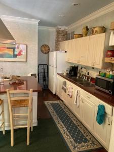 a kitchen with white cabinets and a sink and a table at The Villa Toscana in Chicago