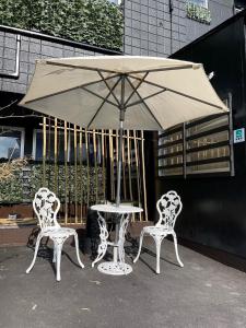 duas cadeiras e uma mesa com um guarda-sol em InnCocoSumu？ - Vacation STAY 02654v em Kirishima