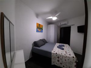 a small bedroom with a bed and a mirror at Condomínio Buritis Centro de Bertioga a 100Mts da praia in Bertioga