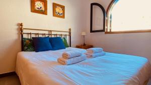 a bedroom with a blue bed with towels on it at Nice flat with terrace in Puerto Rico in Puerto Rico de Gran Canaria +55 photos