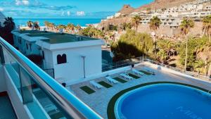 a view from the balcony of a resort with a swimming pool at Nice flat with terrace in Puerto Rico in Puerto Rico de Gran Canaria