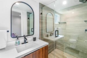 Baño blanco con lavabo y espejo en Stylish Sherman Oaks Townhouse 3bed + 3.5bath All Master Suites, en Los Ángeles
