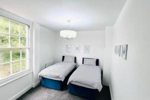 two beds in a white room with a window at Marine Parade House F4 Next to Dover Port, White Cliffs, Beach, Castle in Dover