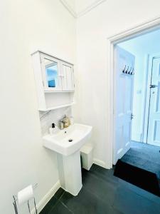 a white bathroom with a sink and a window at Marine Parade House F4 Next to Dover Port, White Cliffs, Beach, Castle in Dover