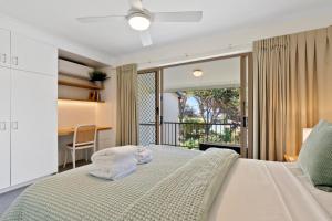 um quarto com uma cama com toalhas em Beach Breakers Resort em Sunrise Beach