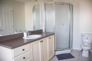 a bathroom with a toilet and a sink and a shower at Beautiful Home 5 Minutes from Ottawa Airport in Ottawa