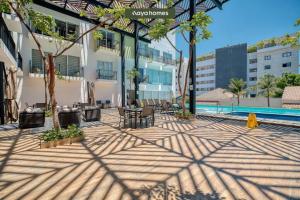 a patio with a table and chairs next to a building at Cozy Studio with Private Balcony - Pool - Gym in Bucerías