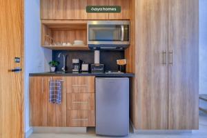 uma cozinha com um frigorífico e um micro-ondas em Cozy Studio with Private Balcony - Pool - Gym em Bucerías
