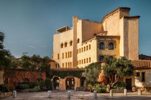 um grande edifício com árvores em frente em Hotel Cala di Volpe, a Luxury Collection Hotel, Costa Smeralda em Porto Cervo