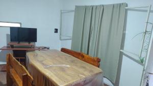 a living room with a television and a wooden table at Tranquilidad en cosquin in Cordoba