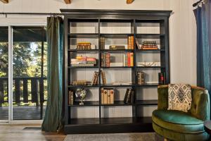 a book shelf with books and a chair in a room at Quiet Tri-Level Chalet w/Breathtaking Views in Lake Arrowhead