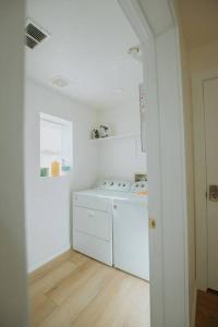 a white kitchen with a washer and dryer at Bohemian Chic an Eclectic Escape-Hot Tub-Pet Friendly-No Pet Fees! in Albuquerque