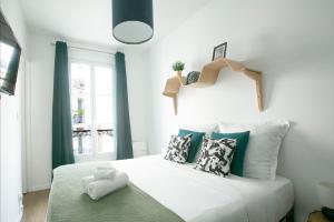 ein Schlafzimmer mit einem großen weißen Bett mit Kissen in der Unterkunft Charming 1 Bedroom Marais Hideaway - FB17A in Paris