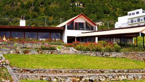 a building with a garden with flowers in front of it at Hotel El Camino Real in Aquitania