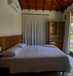 a bedroom with a large bed and a window at Kíria's Village Beach House in Marau +62 photos