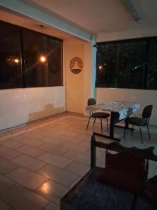 a patio with a table and chairs in a room at Eco hostel 013 in São Vicente