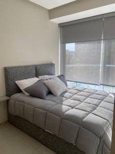 een slaapkamer met een groot bed en een raam bij Apartamento en Bucerías frente al mar, condominio Tayau in Bucerías