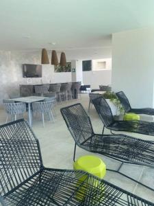 een kamer met stoelen, tafels en stoelen bij Apartamento en Bucerías frente al mar, condominio Tayau in Bucerías