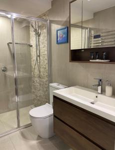 a bathroom with a toilet and a sink and a shower at Tranquillity On The Promenade in Batemans Bay