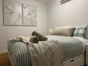 een slaapkamer met een bed met een deken erop bij Tranquillity On The Promenade in Batemans Bay
