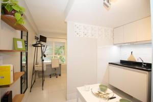 uma cozinha com armários brancos e uma mesa em Studio na melhor quadra da Asa Norte em Brasília
