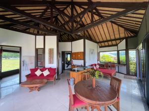 Private Island Stay في Vitouara: غرفة معيشة مفتوحة مع طاولة وكراسي