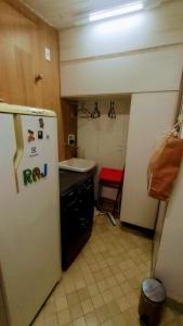 uma cozinha com um frigorífico branco e um lavatório em Apartamento SQN 407 em Brasília