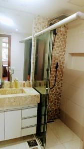 uma casa de banho com 2 lavatórios e uma cabina de duche em vidro. em Apartamento SQN 407 em Brasília