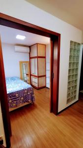 a bedroom with a bed and a door to a room at Apartamento SQN 407 in Brasilia