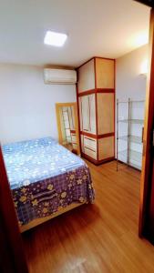 1 dormitorio con 1 cama y suelo de madera en Apartamento SQN 407, en Brasilia