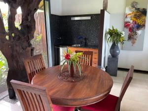una mesa de comedor con un jarrón de flores. en Private Island Experience en Vitouara