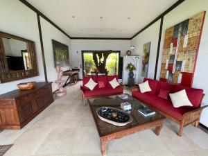 a living room with red couches and a table at Private Island Experience in Vitouara