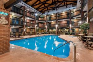 a large pool in a hotel with tables and chairs at Best Western Plus Rio Grande Inn in Durango