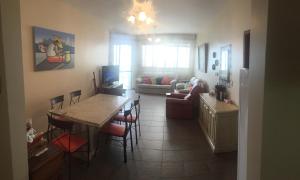 eine Küche und ein Wohnzimmer mit Tisch und Stühlen in der Unterkunft Espaçoso apê 3 quartos à beira da Praia do Forte com piscina e sauna in Cabo Frio