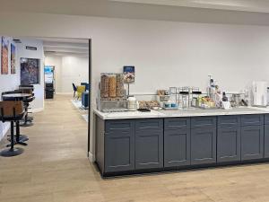 a store with a counter and a room with chairs at Clarion Pointe Winslow I-40 in Winslow