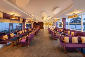 a restaurant with purple chairs and tables and windows at Four Points by Sheraton Mahabalipuram Resort & Convention Center in Mahabalipuram