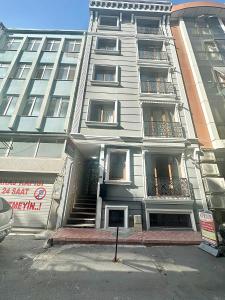 een hoog wit gebouw met een trap ervoor bij Overland Residence in Istanbul