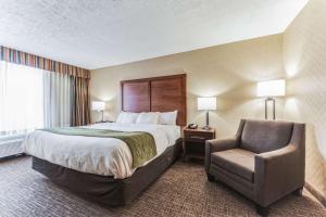Habitación de hotel con cama y silla en Comfort Inn Grantsville-Deep Creek Lake, en Grantsville