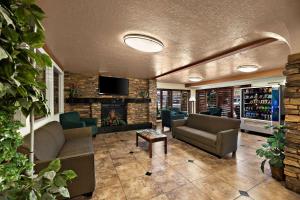 a lobby with couches and a tv in a building at Quality Inn Saint George South Bluff in St. George