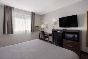 ein Hotelzimmer mit einem Bett und einem Flachbild-TV in der Unterkunft Quality Inn Hall of Fame in Canton