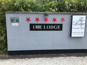 una señal para el lodge con cuatro estrellas rojas en The Lodge at Ruddington en Nottingham