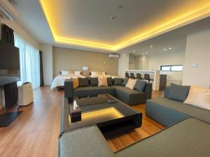 a living room with a couch and a bed at ＆Monde. Okinawa Arena Condominium in Okinawa City