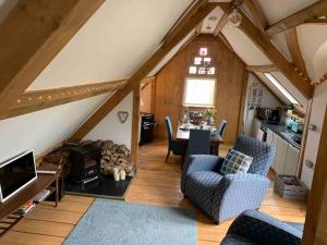 a living room with a table and chairs in a attic at AppleTree Barn - Pembrokeshire Coast National Park in Pembroke