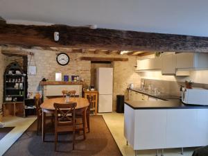 a kitchen and dining room with a table and a clock at Gîte Beaune-la-Rolande, 3 pièces, 4 personnes - FR-1-590-114 in Beaune-la-Rolande