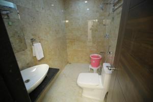 a bathroom with a toilet and a sink and a shower at RADHA RANI RESIDENCY in Khammam +27 photos